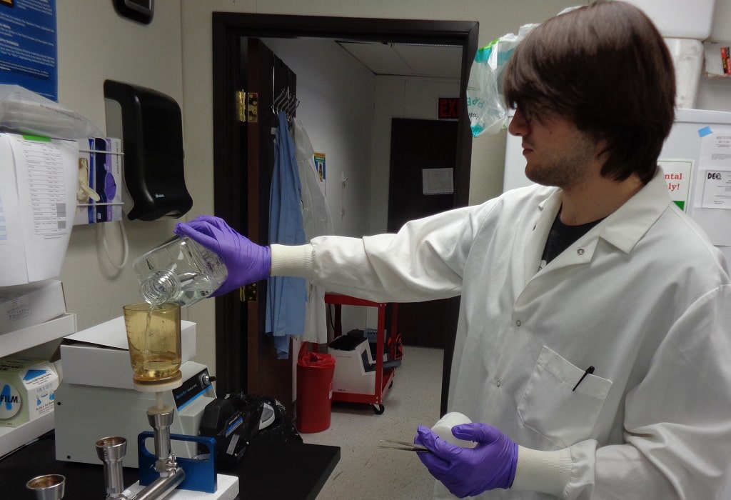 USGS microbiologist pours a groundwater sample into a sterile laboratory filter cup